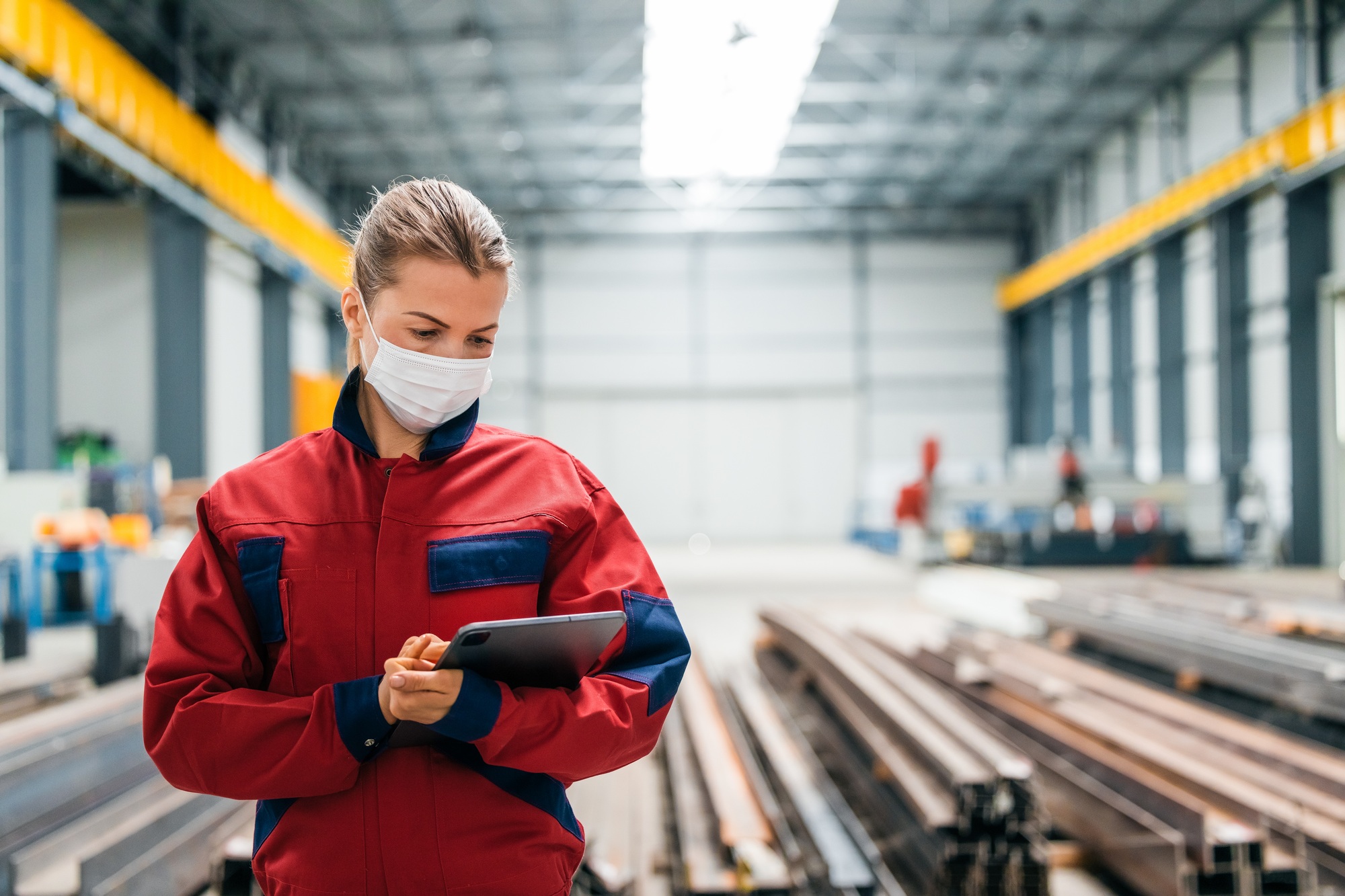 Portrait of a manager in manufacturing hall looking at digital tablet.